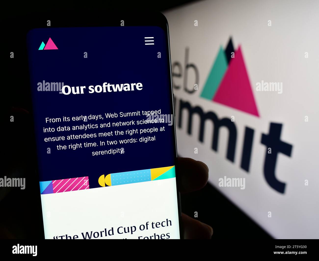 Person holding cellphone with web page of annual technology conference Web Summit (Lisbon) in front of logo. Focus on center of phone display. Stock Photo