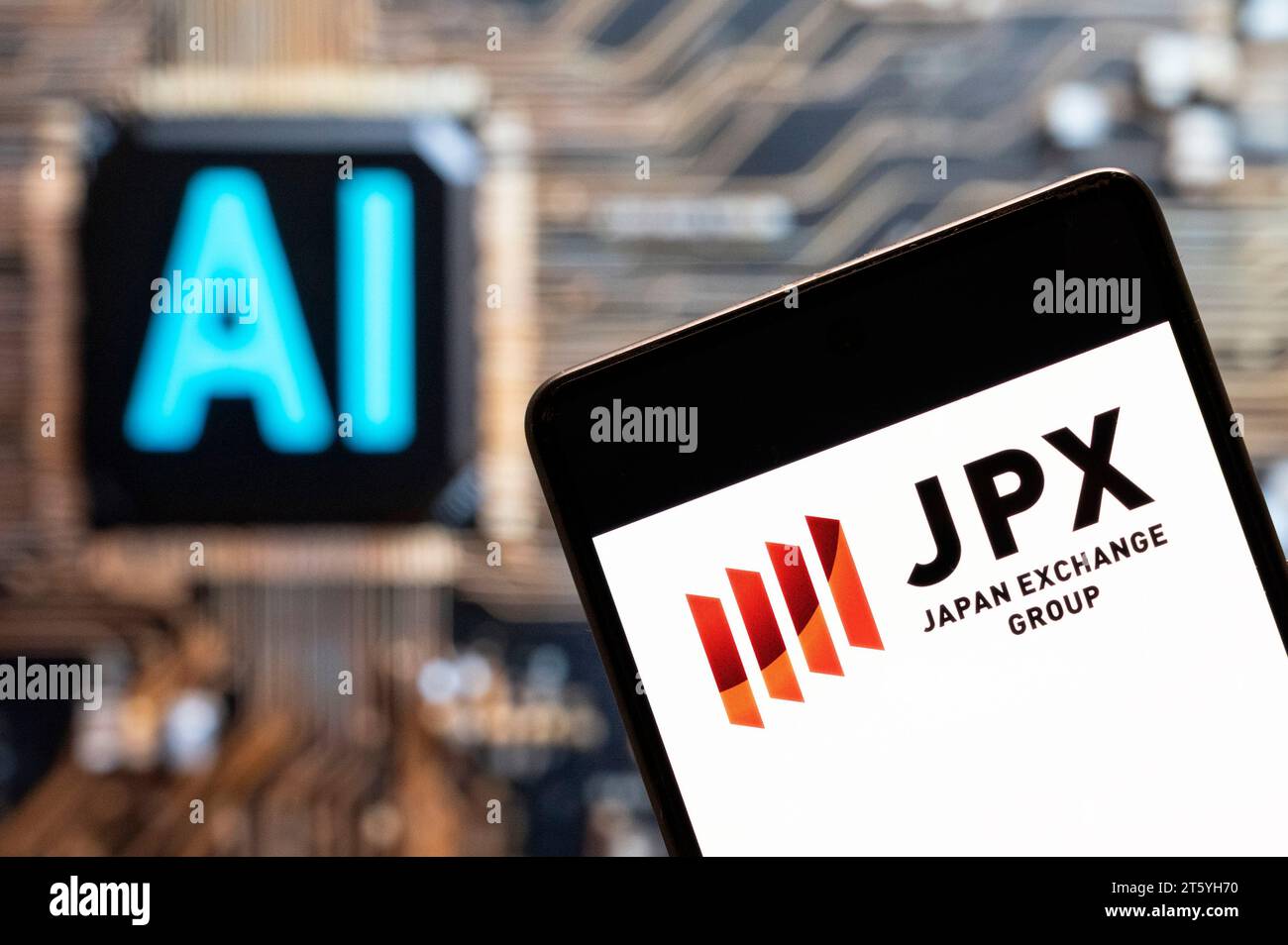 In this photo illustration, the Japan Stock Exchange Group (JPX) logo seen displayed on a smartphone with an Artificial intelligence (AI) chip and symbol in the background. Stock Photo