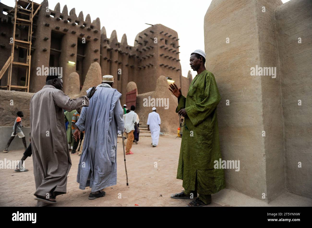 MALI, Djenne, Grand Mosque built from clay is a UNESCO world heritage site, muslim men going for prayer in the evening, wearing the traditional robe Boubou made from cotton or damask fabric Stock Photo