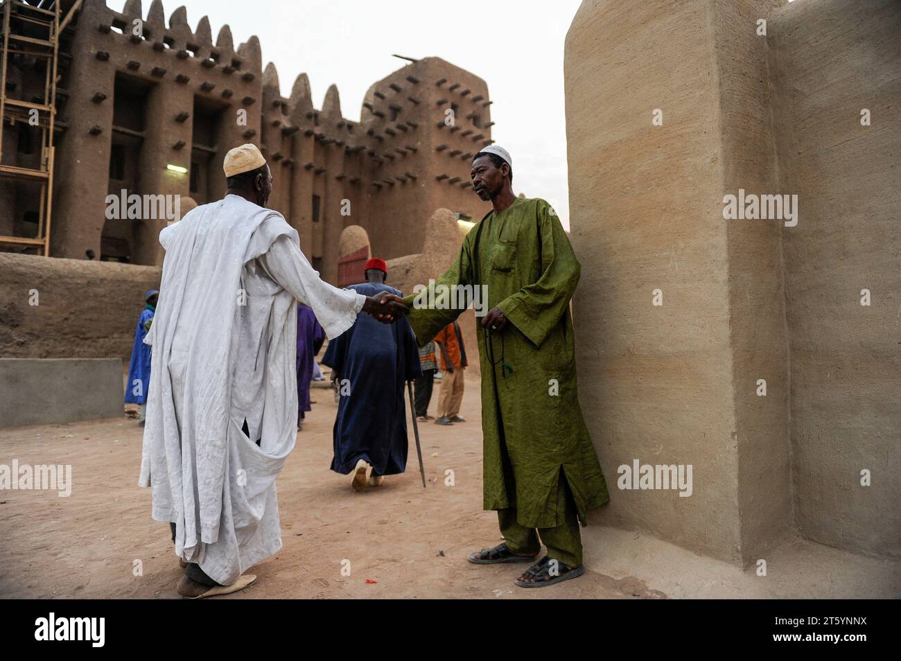 MALI, Djenne, Grand Mosque built from clay is a UNESCO world heritage site, muslim men going for prayer in the evening, wearing the traditional robe Boubou made from cotton or damask fabric Stock Photo