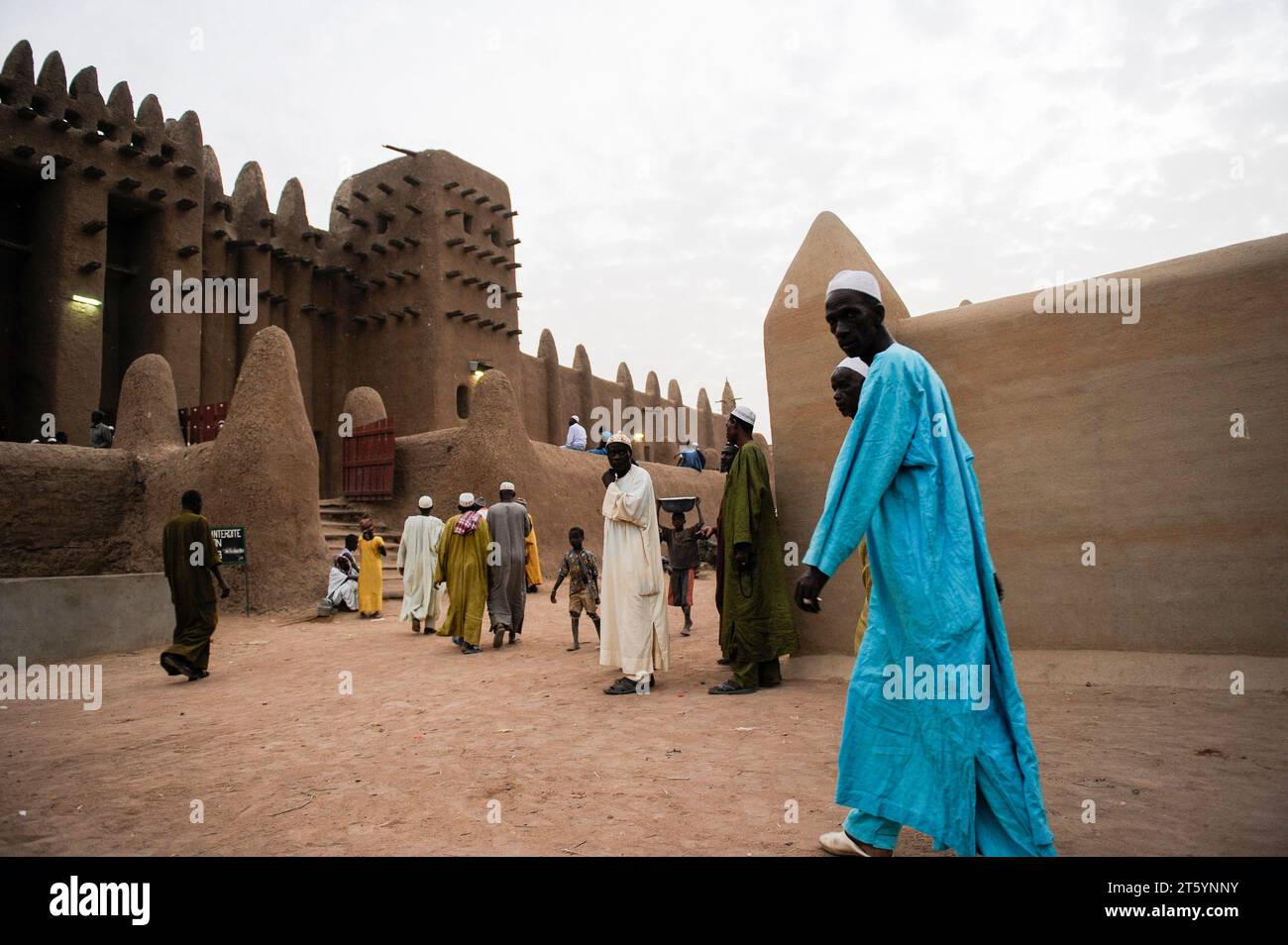 MALI, Djenne, Grand Mosque built from clay is a UNESCO world heritage site, muslim men going for prayer in the evening, wearing the traditional robe Boubou made from cotton or damask fabric Stock Photo