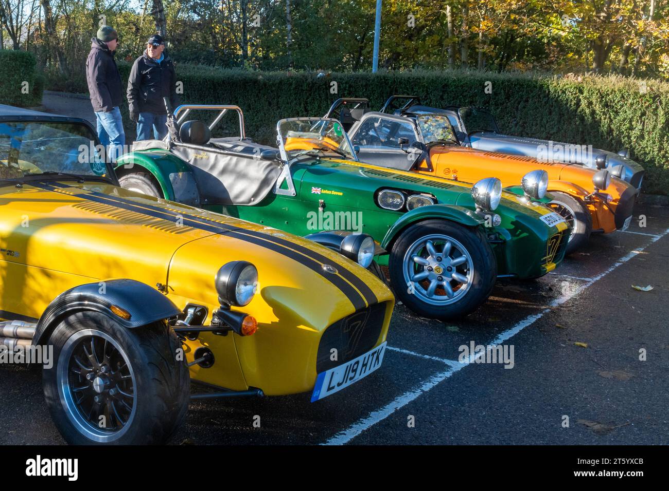 Caterham and Lotus Seven club members and cars parked in car park