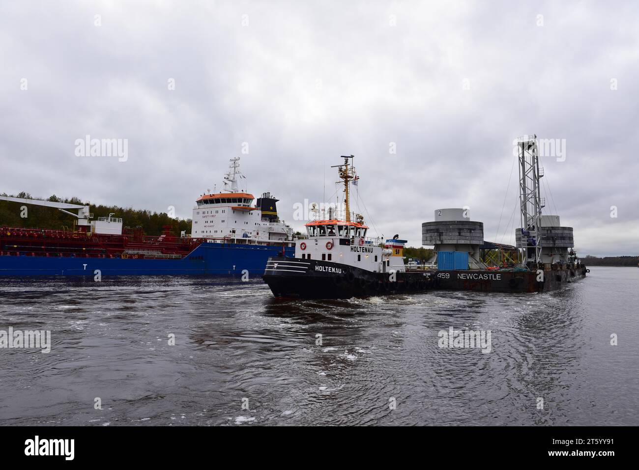 Tugboat towing a pontoon with offshore installation in the Kiel Canal