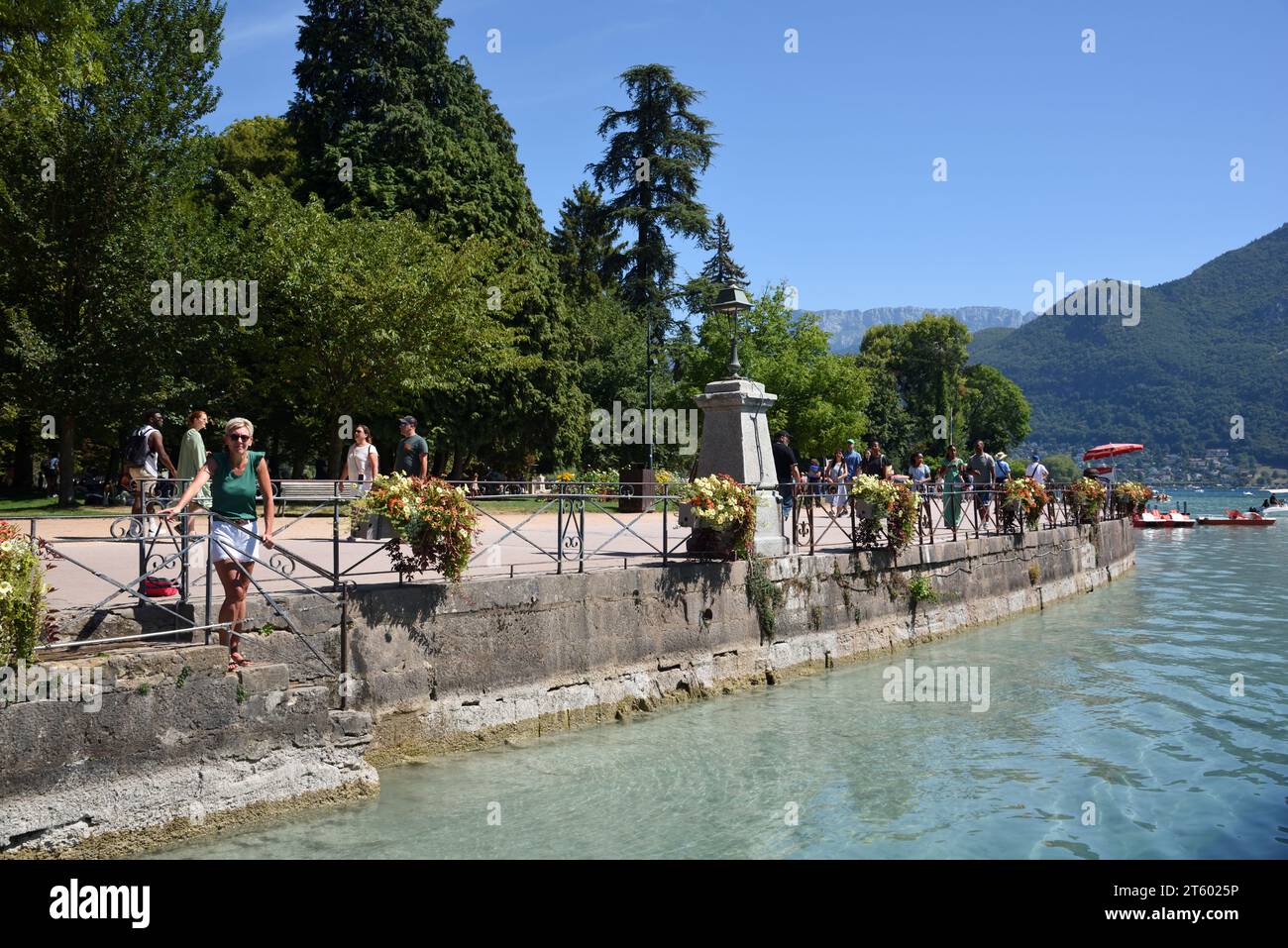 Tourists Walking Along the Quai Napoléon in the Jardins de l'Europe on the Lakeside or Waterfront of Annecy Lake Annecy Haute-Savoie France Stock Photo