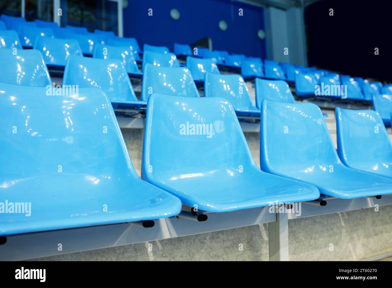 No people on blue plastic chairs of empty tribune at spacious modern stadium for fans of various sports matches, competitions and games Stock Photo