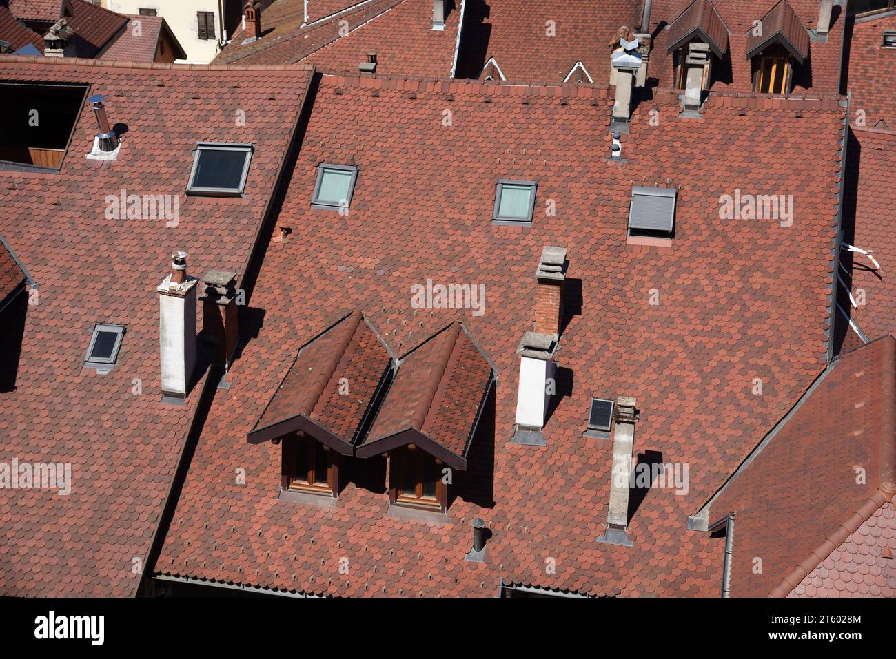 Typical Scalloped Roof Tiles, Tall Chimneys, Roof Windows, Dormer Window & Rooftops of the Old Town or Historic District of Annecy Haute Savoie France Stock Photo