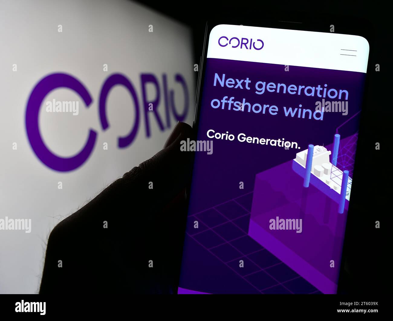 Person holding cellphone with webpage of renewables investment company Corio Generation Limited with logo. Focus on center of phone display. Stock Photo