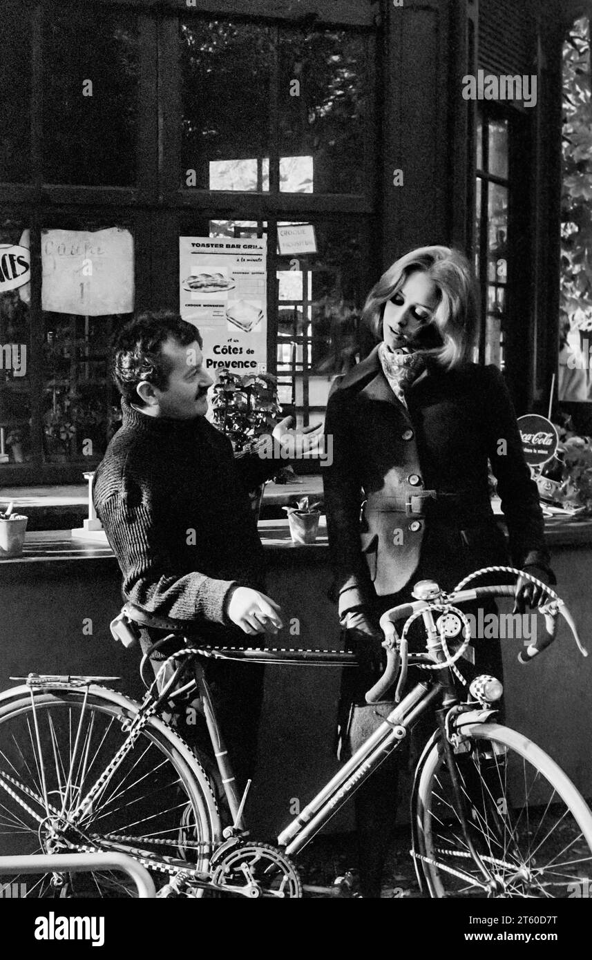 1960s, woman fashion model chatting with food and drink kiosk manager about bikes, Jardin des Tuileries garden, Paris, France, Europe, Stock Photo