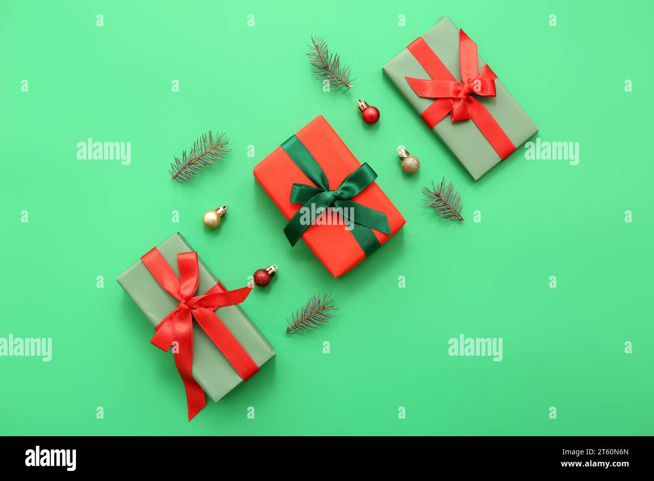 Gift boxes with fir branches and Christmas balls on green background ...