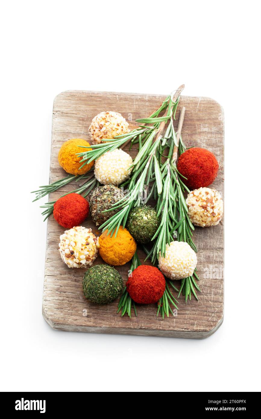 Cheese  balls covered with various spices and nuts decorated with rosemary sticks isolated on white Stock Photo
