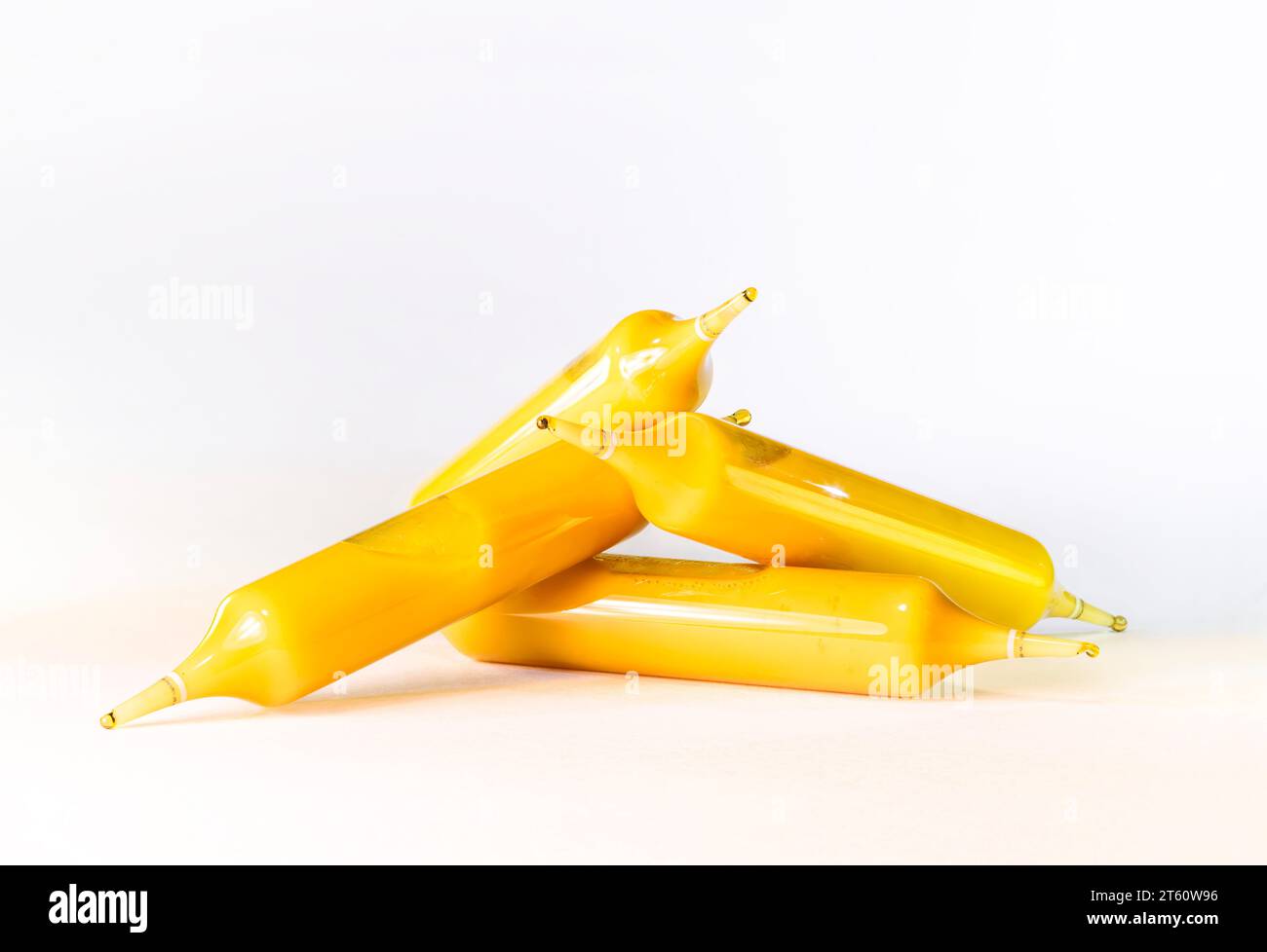 Phials or ampoules stacked containing a golden supplement based on