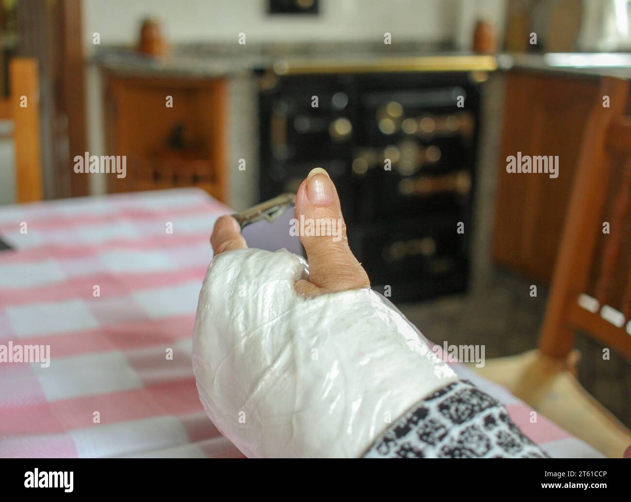 old person with a cast arm watching a mobile phone Stock Photo Alamy