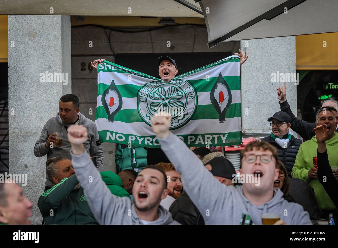 Madrid, Spain. 07th Nov, 2023. Celtic fans chant as another raises a flag with the shield of the Scottish club in the main square of Madrid where the Scottish fans have gathered hours before the Champions League match against Atlético de Madrid. (Photo by David Canales/SOPA Images/Sipa USA) Credit: Sipa USA/Alamy Live News Stock Photo