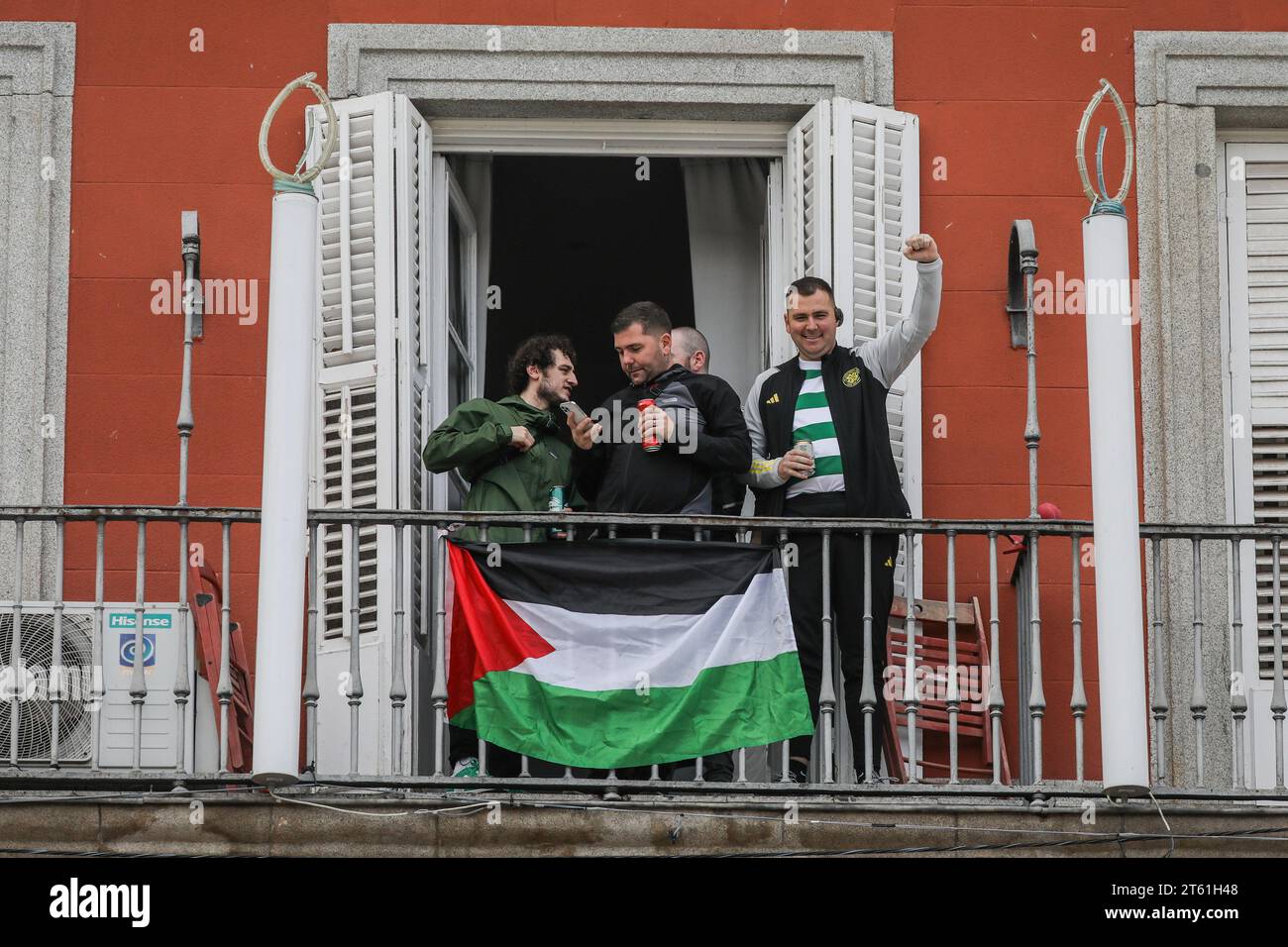 Madrid, Spain. 07th Nov, 2023. Scottish Celtic fans watch and cheer their club from a balcony adorned with a Palestinian flag in the main square of Madrid where the Scottish fans have gathered hours before the Champions League match against Atletico Madrid. (Photo by David Canales/SOPA Images/Sipa USA) Credit: Sipa USA/Alamy Live News Stock Photo