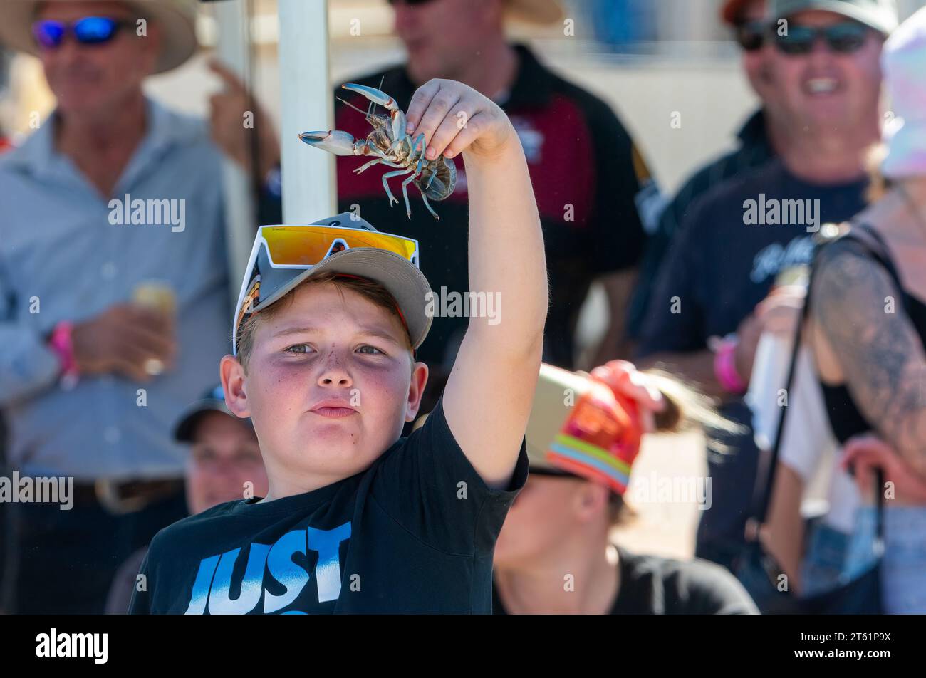 Young boy holding a yabby prior to the yabby race in Boulia, Queensland, QLD, Australia Stock Photo