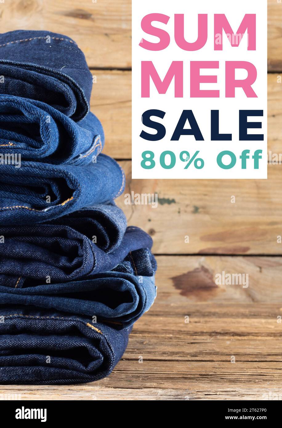 Composite of summer sale 80 percent off text over denim trousers on wooden background Stock Photo