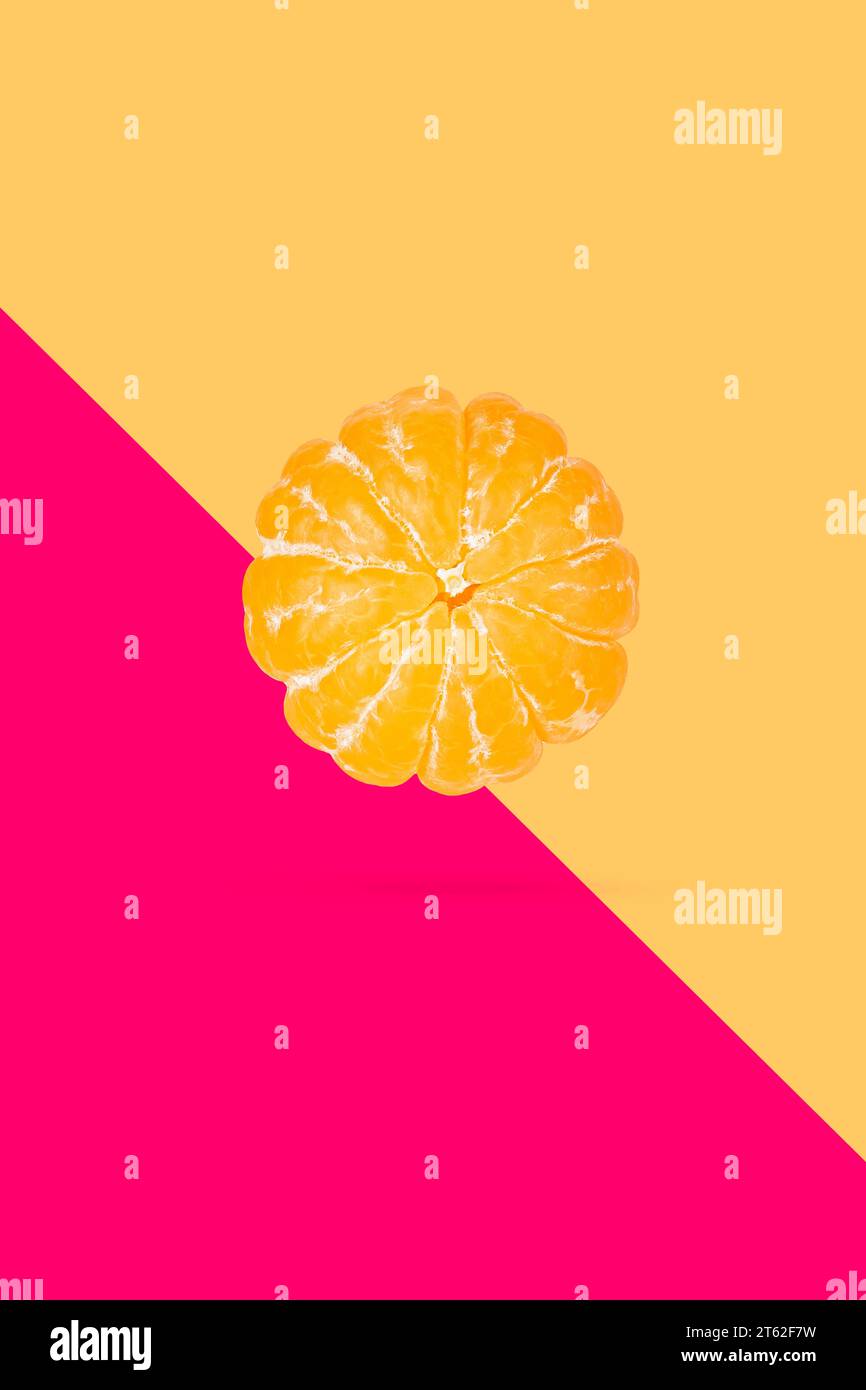 Peeled mandarin or clementine isolated on soft peach color background ...