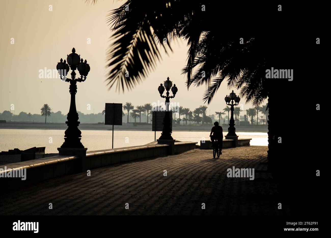 People walking and jogging in corniche during sunset. Stock Photo