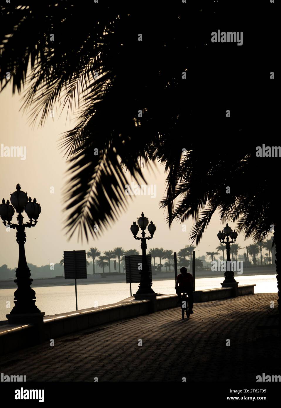 People walking and jogging in corniche during sunset. Stock Photo