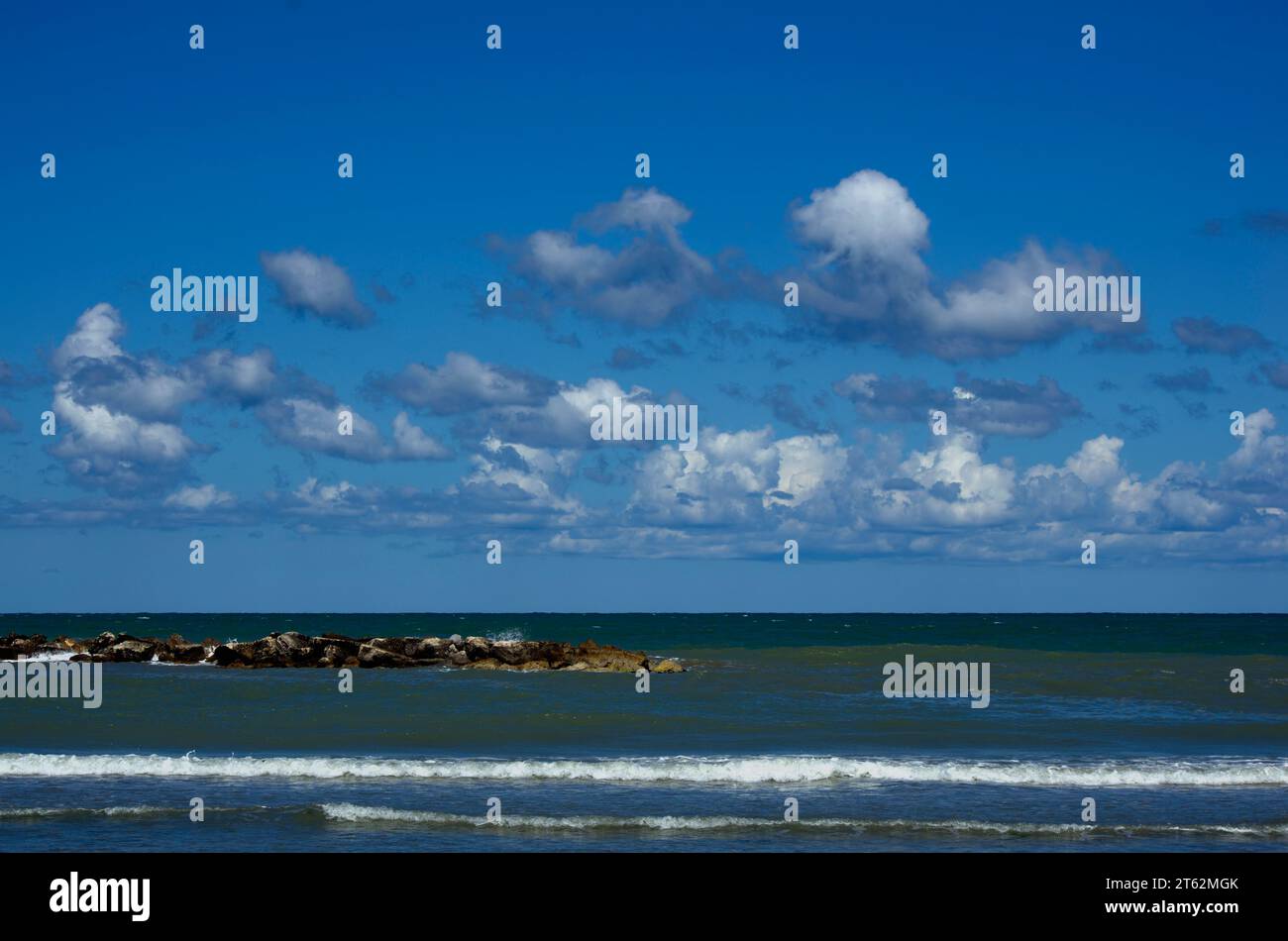 panorama del mare e degli scogli contro il cielo parzialmente nuvoloso Stock Photo