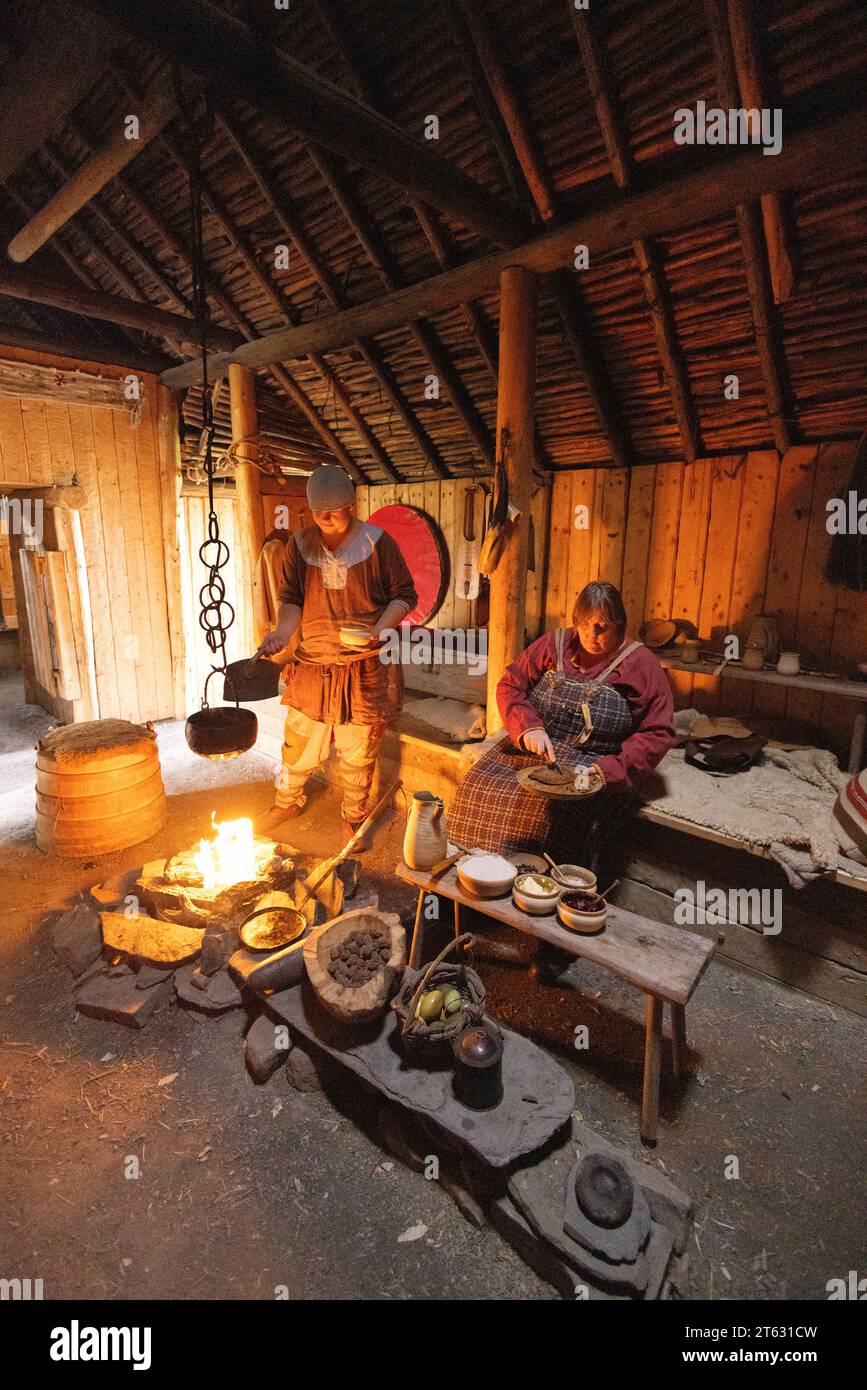 L'anse aux Meadows UNESCO site of ancient norse/viking settlement, Newfoundland Canada. Tourists watchin interior reconstruction of cooking facilities Stock Photo