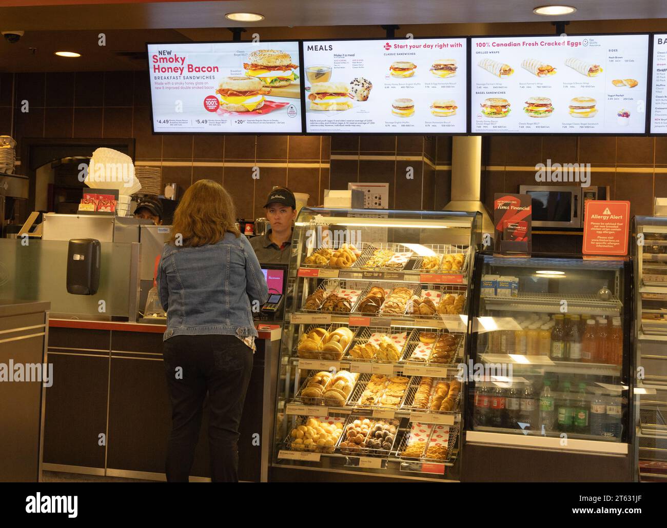 Tim Hortons coffee shop; interior; a customer buying coffee being served by a staff member, St. Johns, Newfoundland Canada Stock Photo