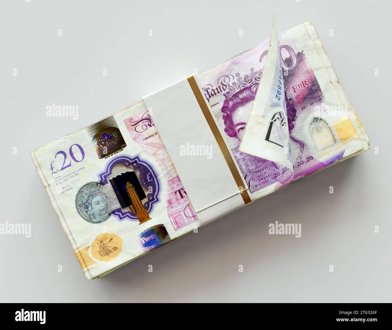 A bundled wad of british pound banknotes on an isolated light background - 3D render Stock Photo