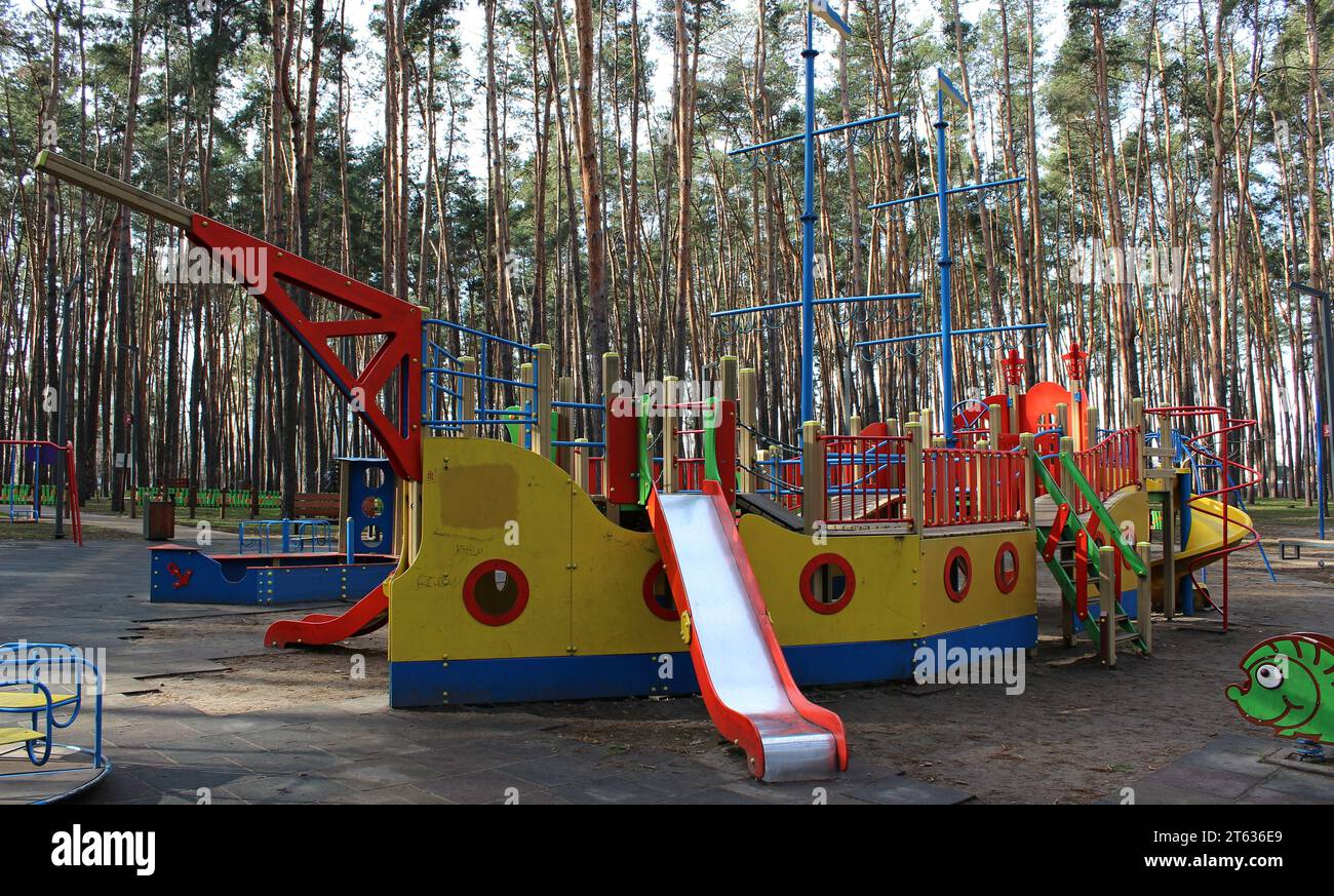 Outdoor game complex with children's slides in the form of a ship with masts in the recreational area Stock Photo