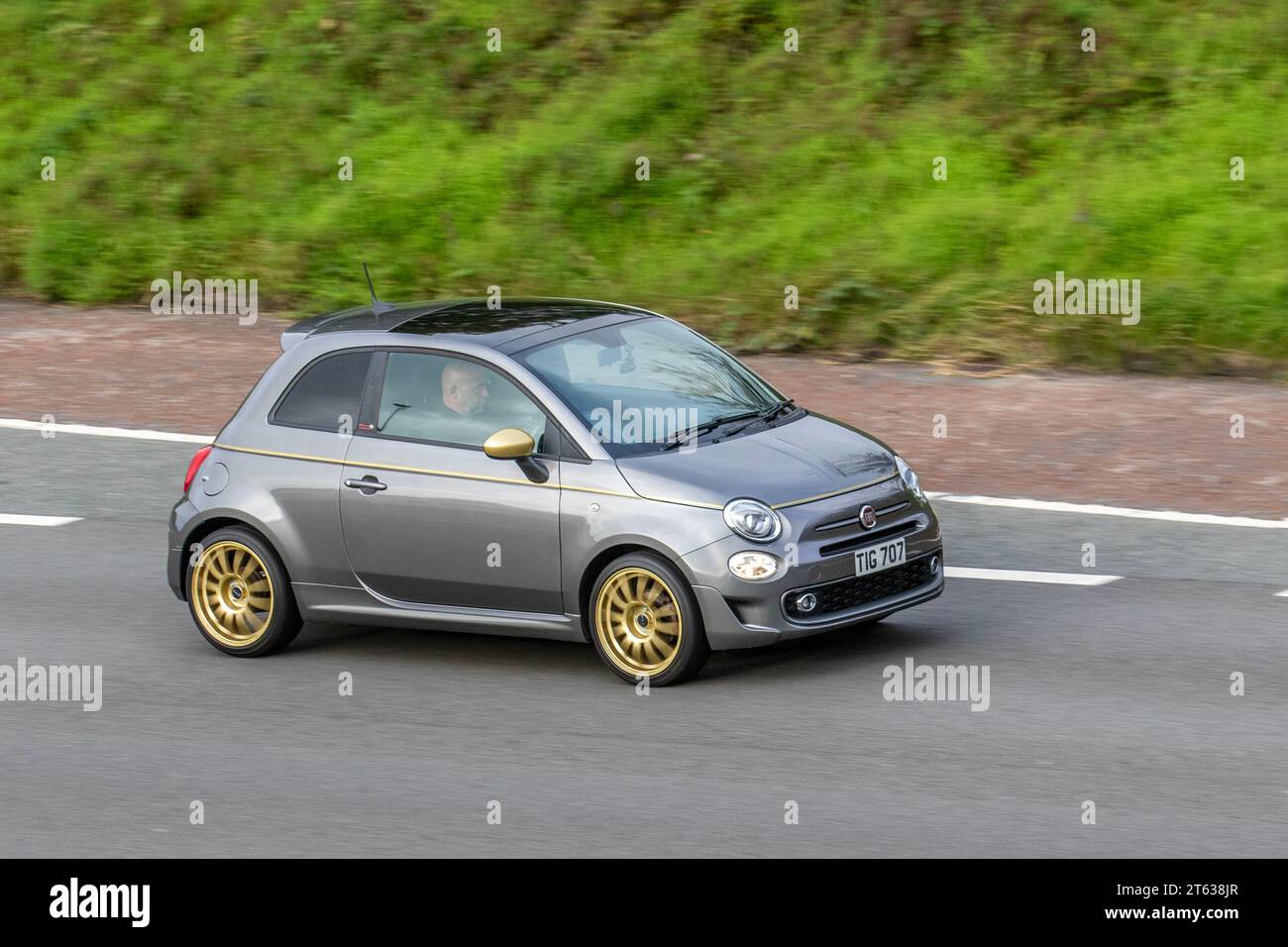 2017 Fiat 500 S Start/Stop Grey Car Hatchback PetroL 1242 cc, 1.2 L 4-cylinder with Gold wheels; travelling at speed on the M6 motorway in Greater Manchester, UK Stock Photo