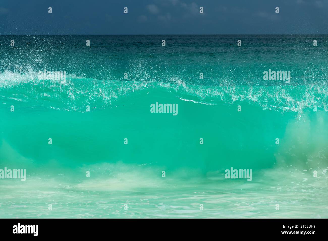Powerful giant big wave breaking on the shore in the Seychelles, ocean abstract Stock Photo