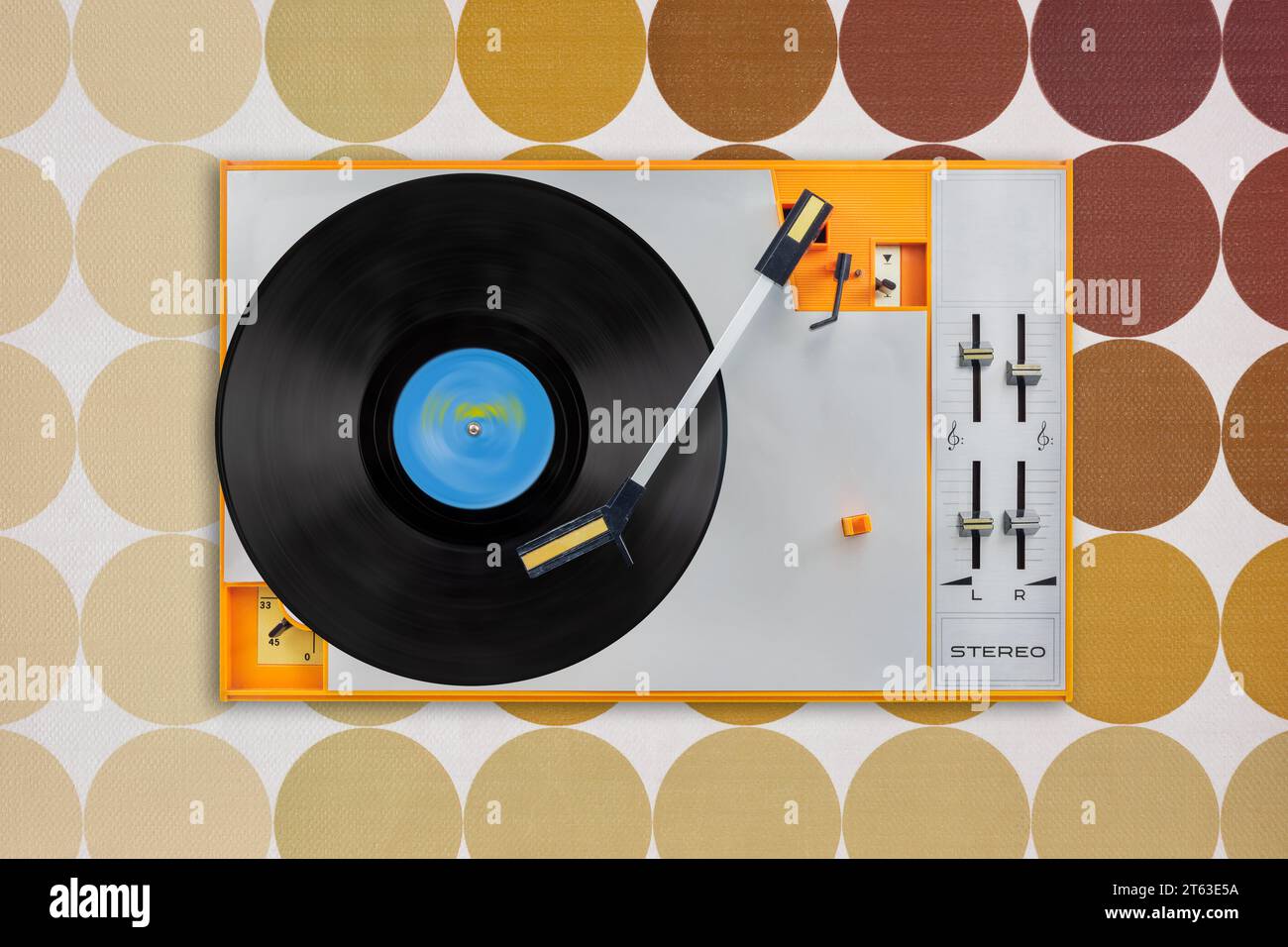 Top view of an orange vintage record player in front of retro brown wallpaper Stock Photo