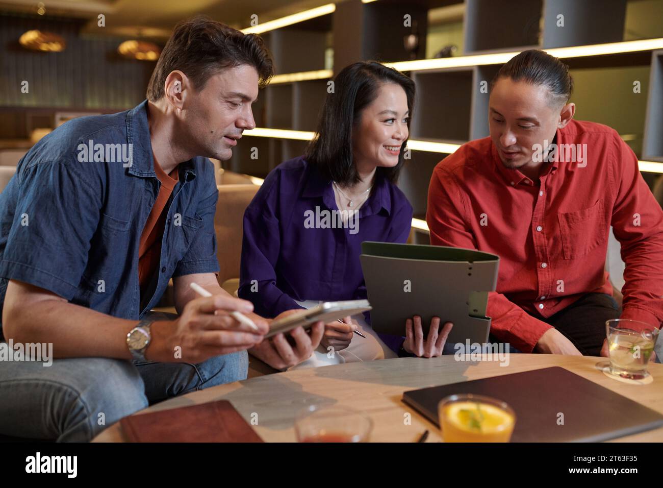 Group of cheerful colleagues working on project documentation Stock Photo