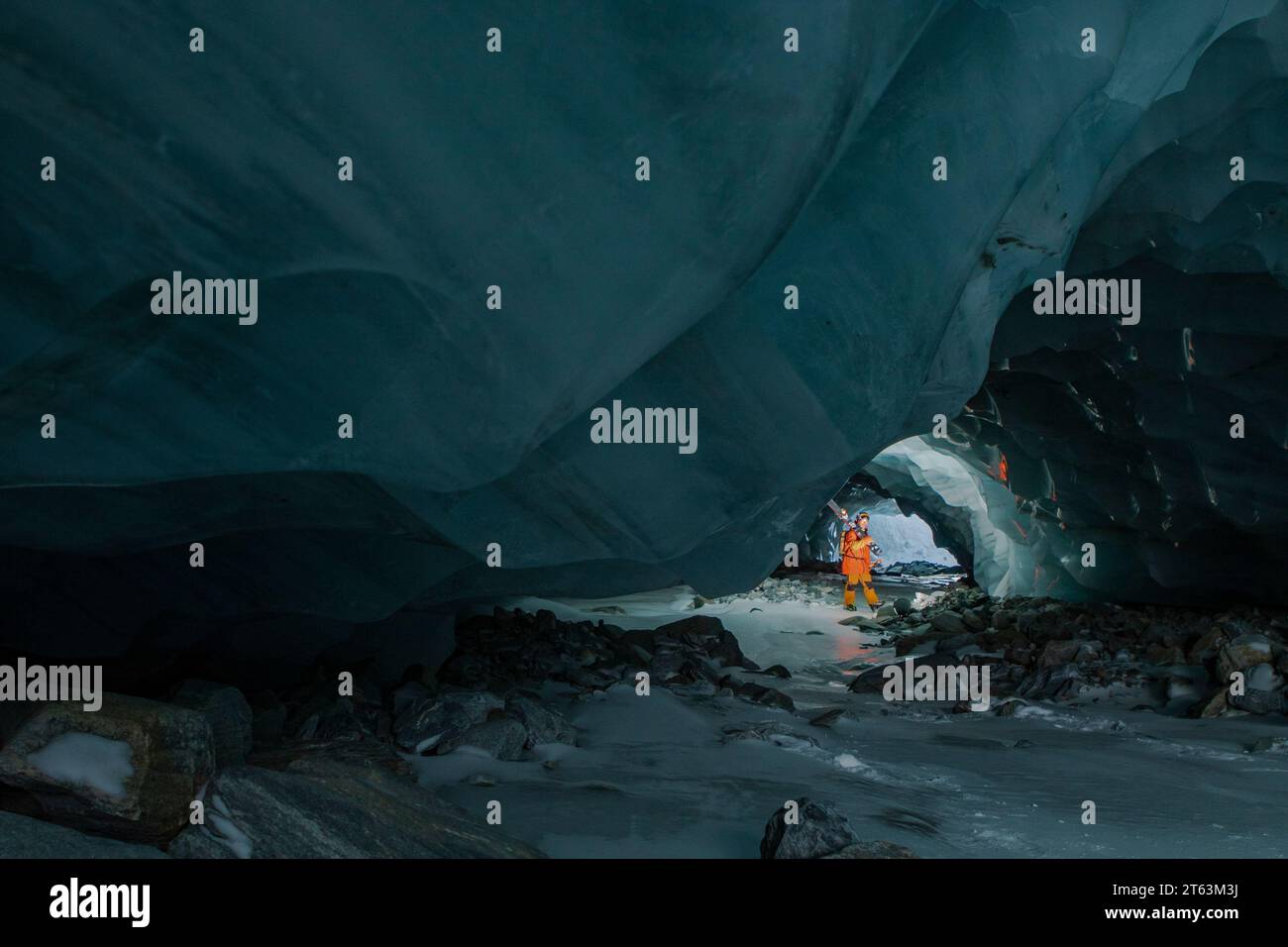 Side view of skier with ski poles walking in cave at snowy mountain while exploring during vacation at Swiss Alps Stock Photo