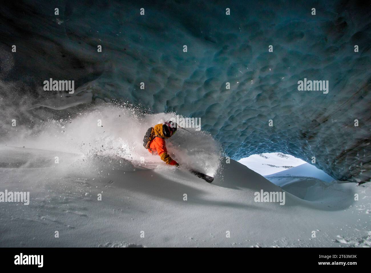 Unrecognizable skier in warm suit skiing on slope in cave at snowy mountain during vacation at Swiss Alps Stock Photo