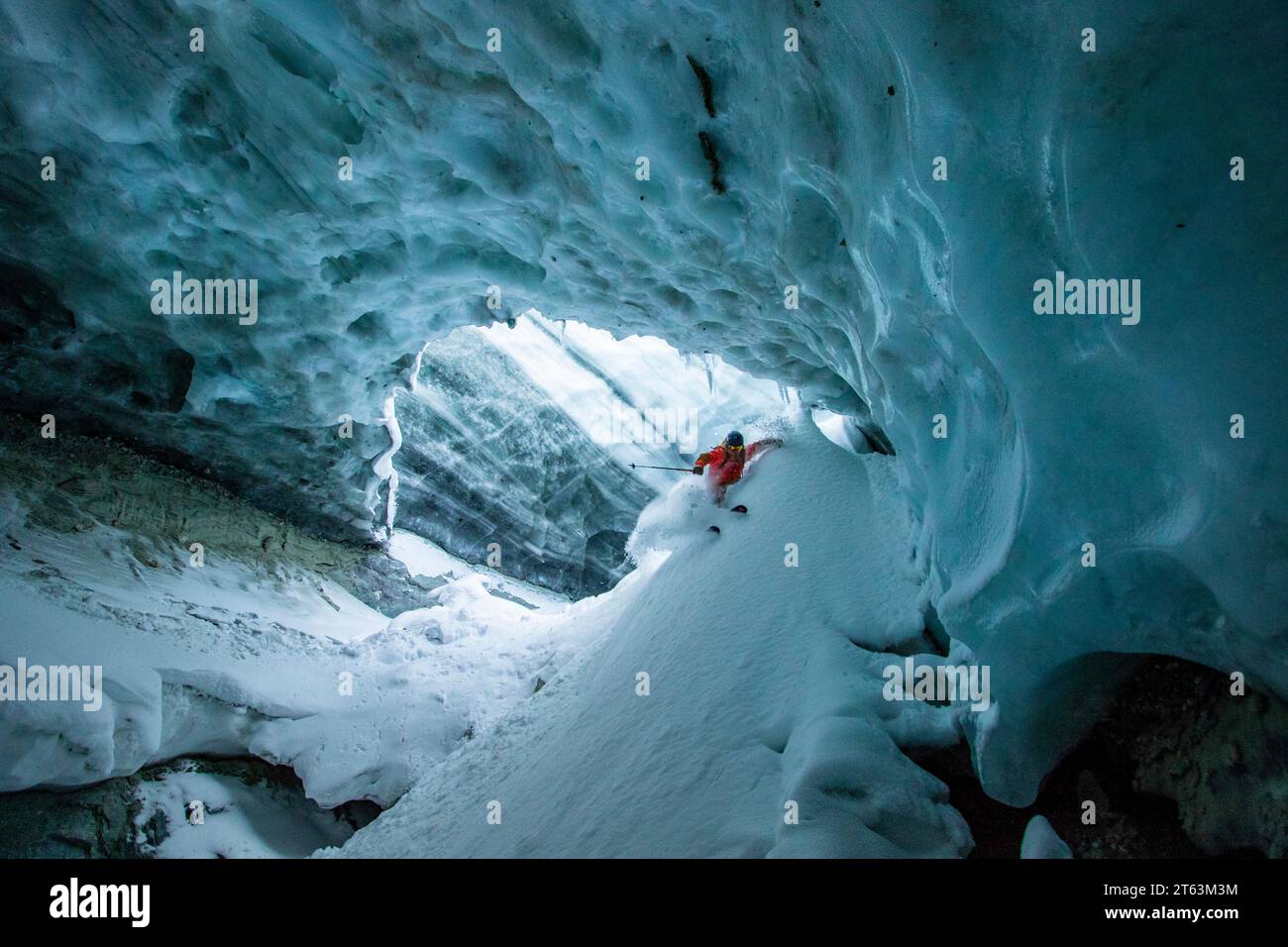 Unrecognizable skier in warm suit skiing on slope in cave at snowy mountain during vacation at Swiss Alps Stock Photo