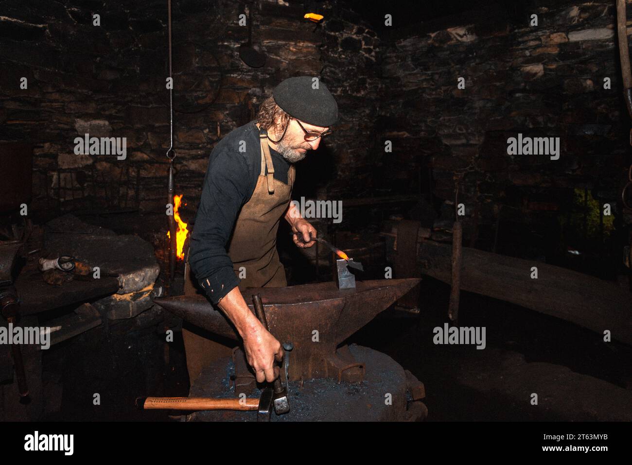 A blacksmith works meticulously, forging an 18th century hydraulic ...