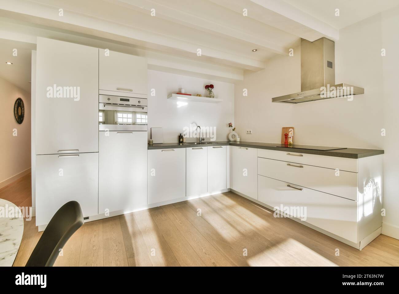 Interior of spacious open plan kitchen with white cabinets and modern ...