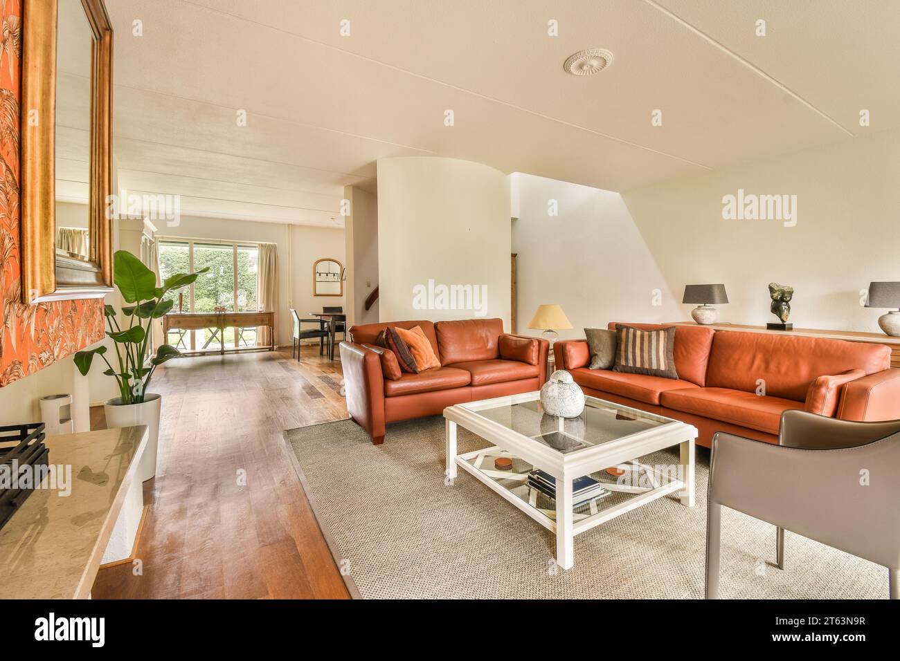 Interior of spacious living room with orange couches and coffee table ...