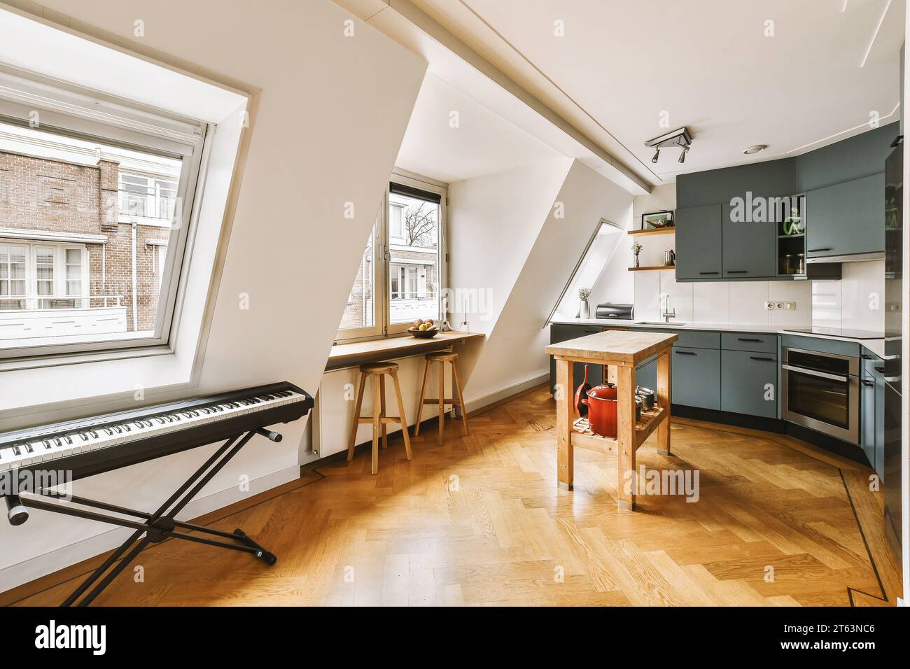 Piano with wooden table in spacious kitchen with modern appliances and ...