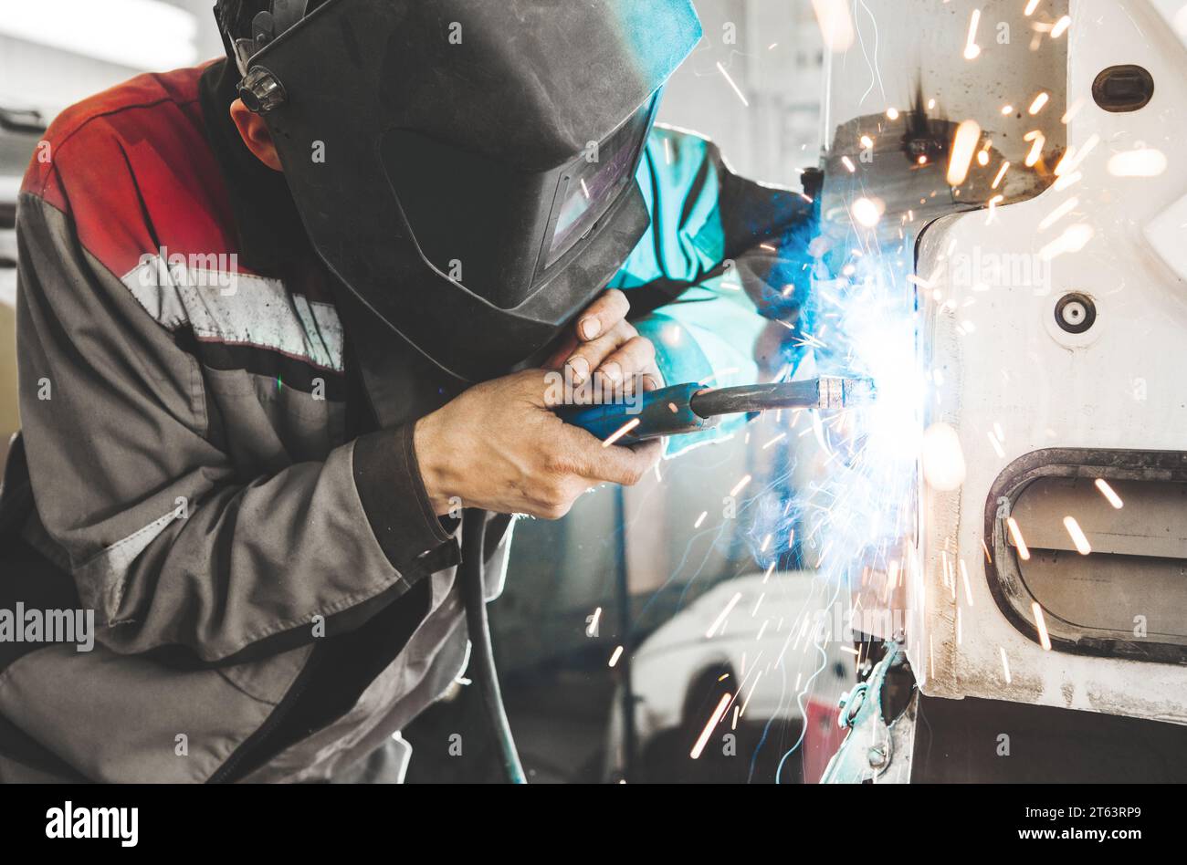 Industrial welder welds back bodywork of car. Weld of vehicle Stock Photo Alamy
