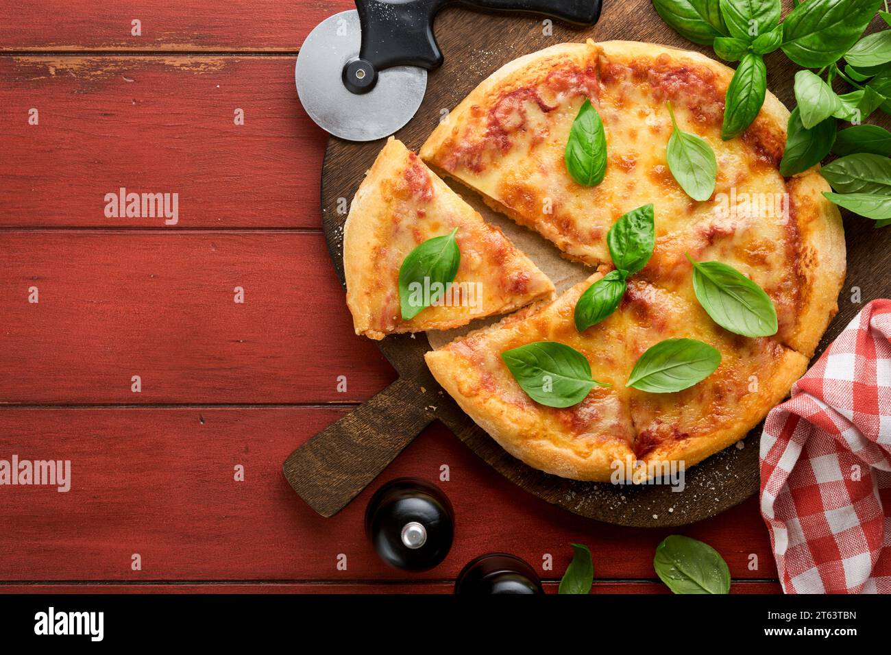 Margarita pizza. Traditional neapolitan margarita pizza and cooking ingredients tomatoes basil on wooden table backgrounds. Italian Traditional food. Stock Photo
