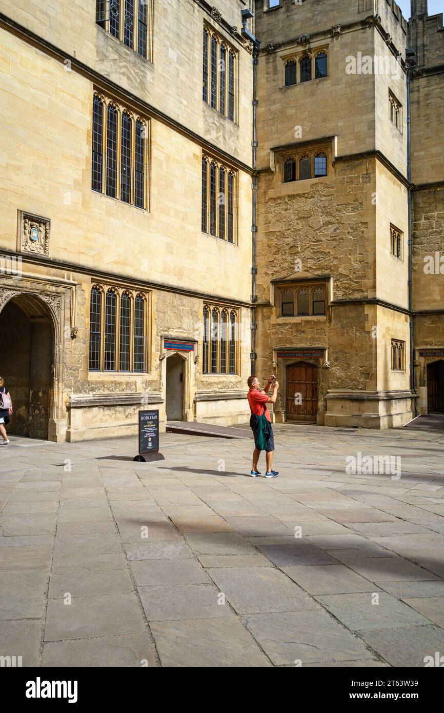 Lone tourist photographing with his smartphone by the Bodleian Library, Oxford, England, UK Stock Photo