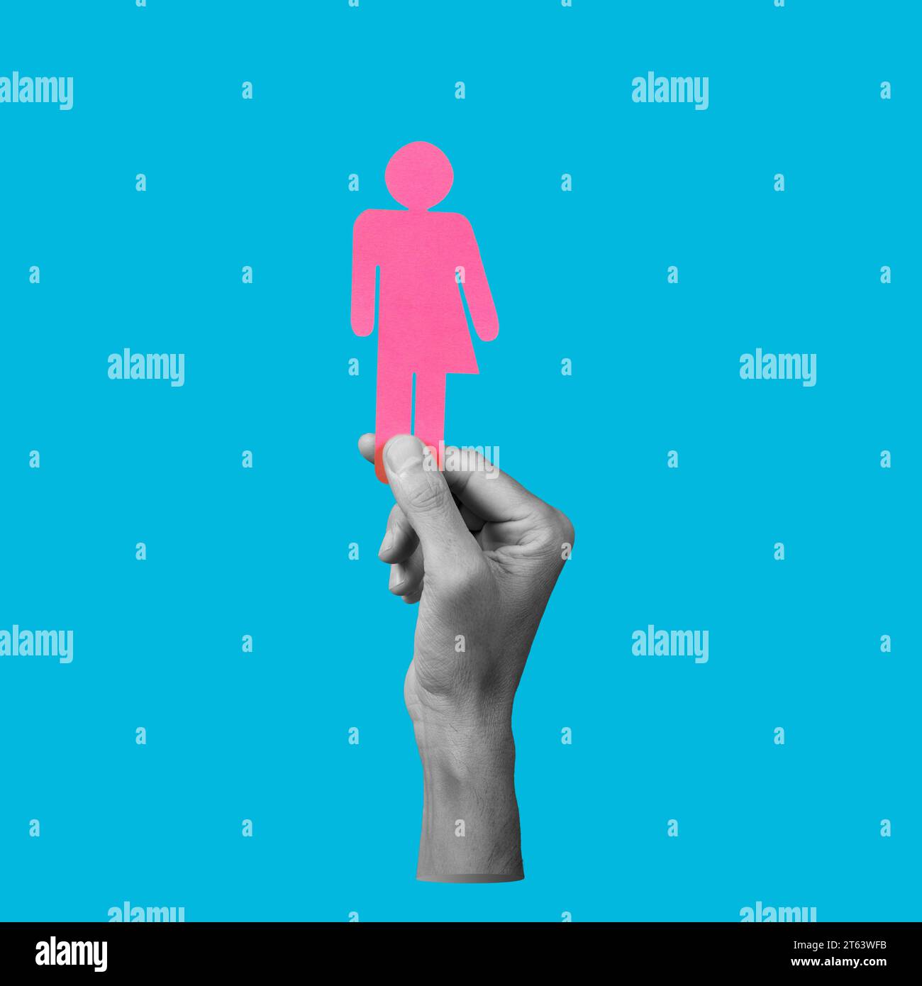 the hand of a man in black and white holding a pink gender neutral icon on a blue background Stock Photo
