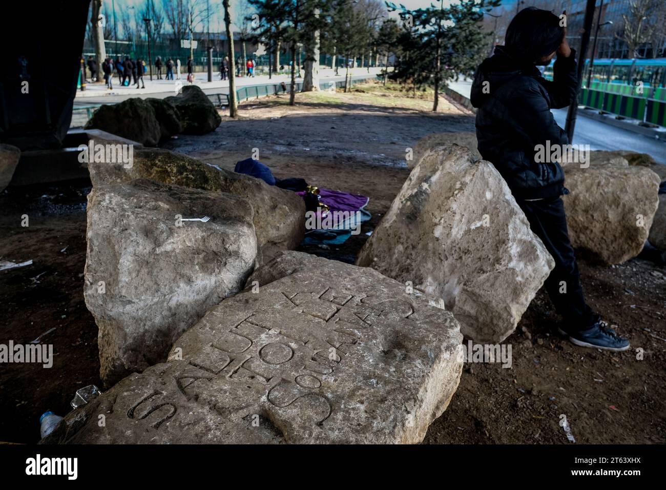 Michael Bunel/Le Pictorium - Exile in the land of human rights - 12/03/2018 - France/Ile-de-France (region)/Paris - A stonemason from the association -Coeurs de Pierres et Solidarite- is busy inscribing messages on the stones installed under one of the bridges at Porte de La Chapelle. The association is taking part in the tribute to the young Sudanese man, Karim Ibrahim, who died on Thursday March 8. He was found near the first reception and accommodation center for migrants installed in November 2016 by the City of Paris and managed by Emmaus. to prevent people from settling. Marc Stock Photo