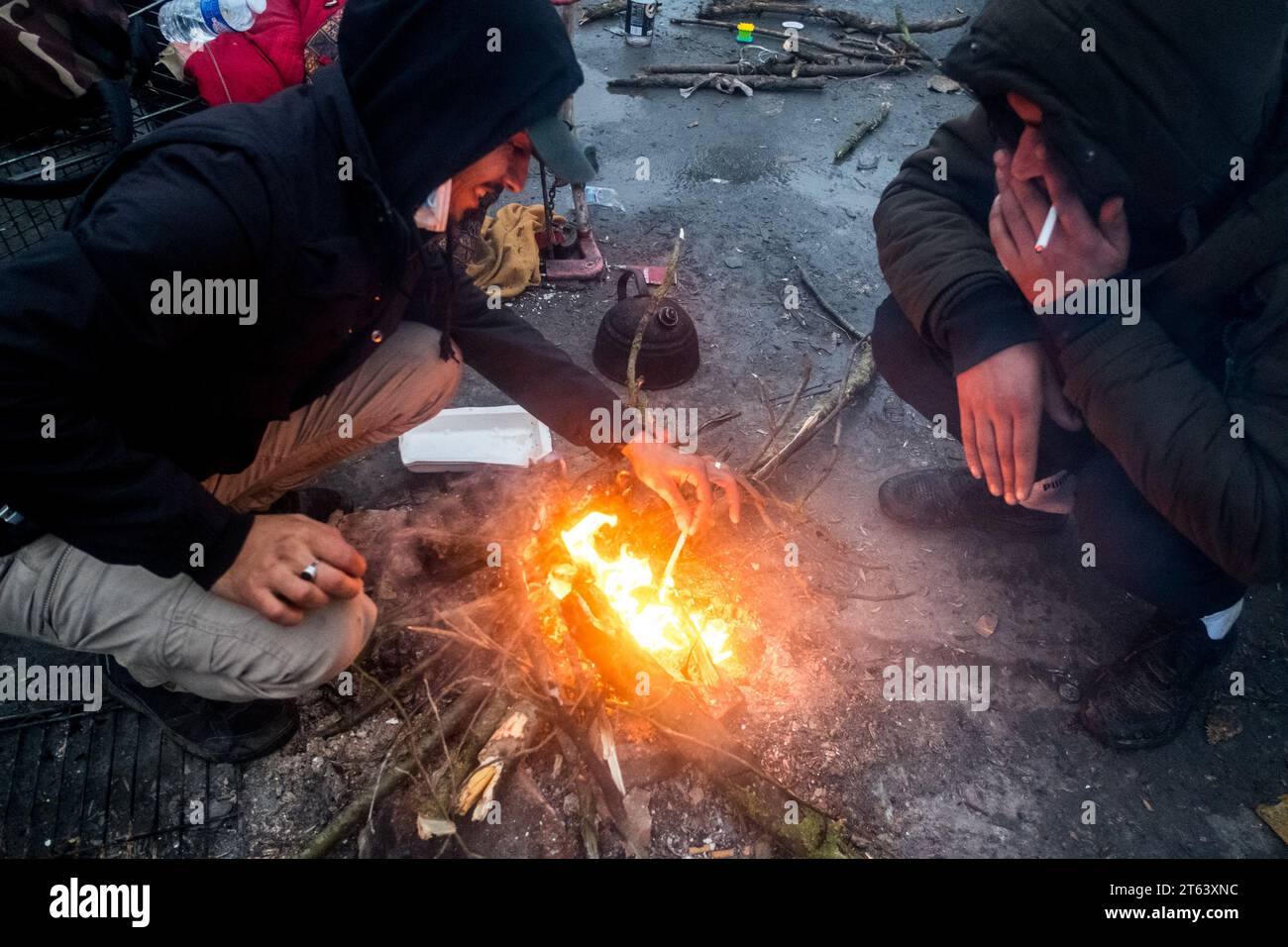 Michael Bunel/Le Pictorium - November 2016, Evacuation of the Calais 'Jungle - 16/11/2021 - France/Haut de France/Grande Synthe - Two men smoke a cigarette during the evacuation of the camp. A camp of over 1,000 people, mostly Kurds and Iraqis, had taken up residence in the shopping area of the Auchan store in Grande Synthe. The prefecture ordered the dismantling of the camp this morning. The exiles were not notified in accordance with the government's undertakings. November 16, 2021. Grande Synthe. France. November 2016, the 'jungle' of Calais, the largest shantytown in Europe Stock Photo