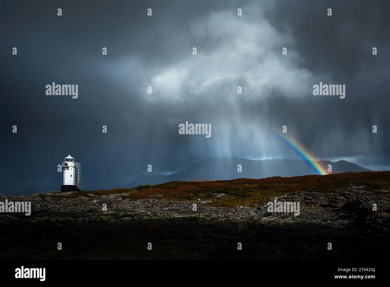 A rain cloud passing behind behind Rhue lighthouse on the West coast of Scotland. Stock Photo