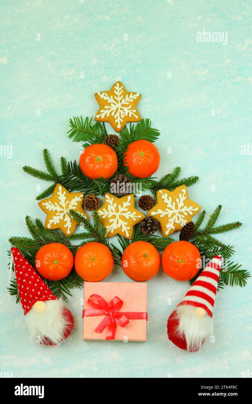 Blue winter background with pattern of christmas decorations, tangerines, cones, gingerbread Stock Photo