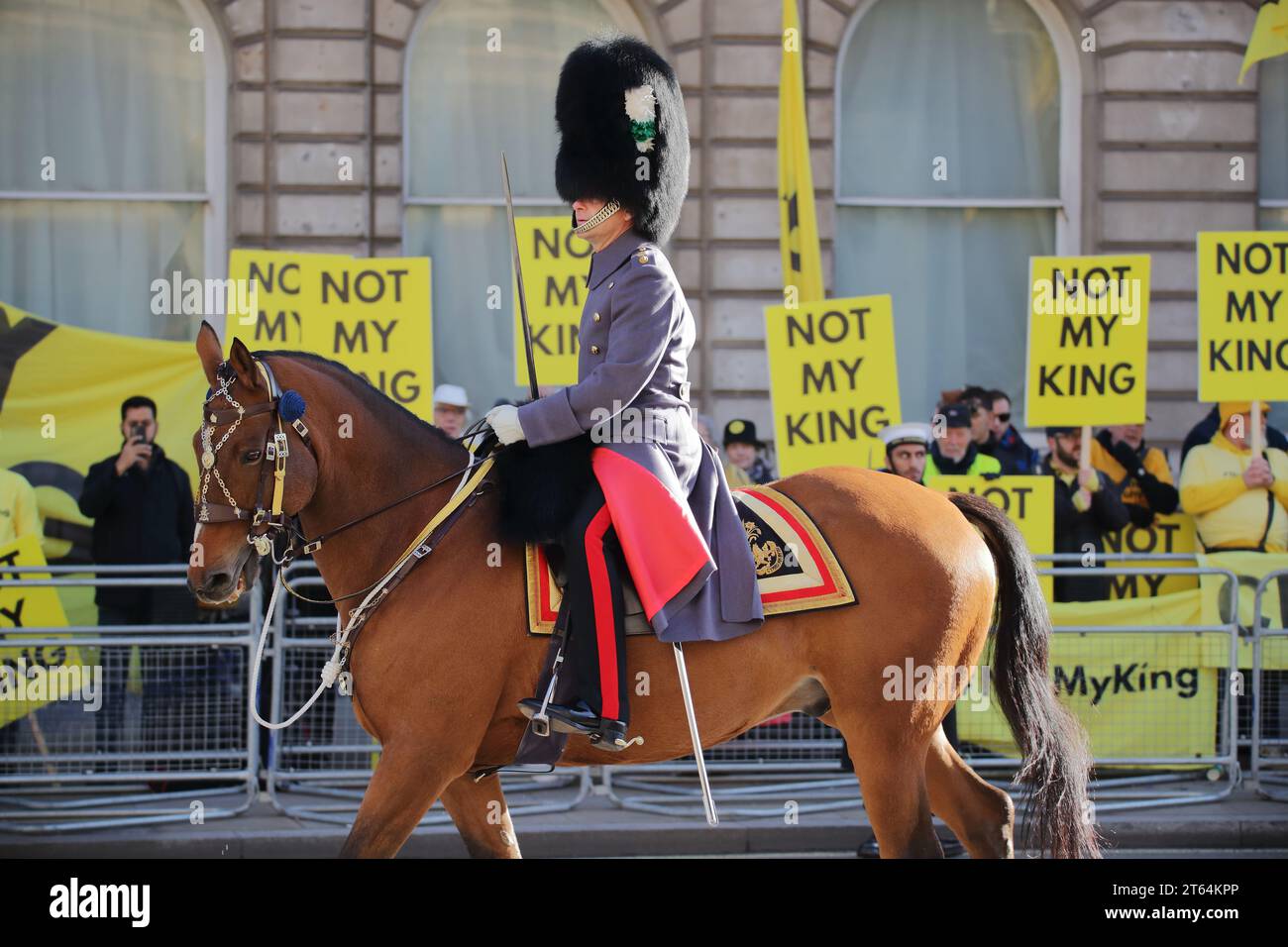 London, UK. 7th November 2023. First State Opening of the Parliament for King Charles III since his coronation. A Horse Guard on Whitehall passing anti-monarchist protesters with banners and placards. Stock Photo