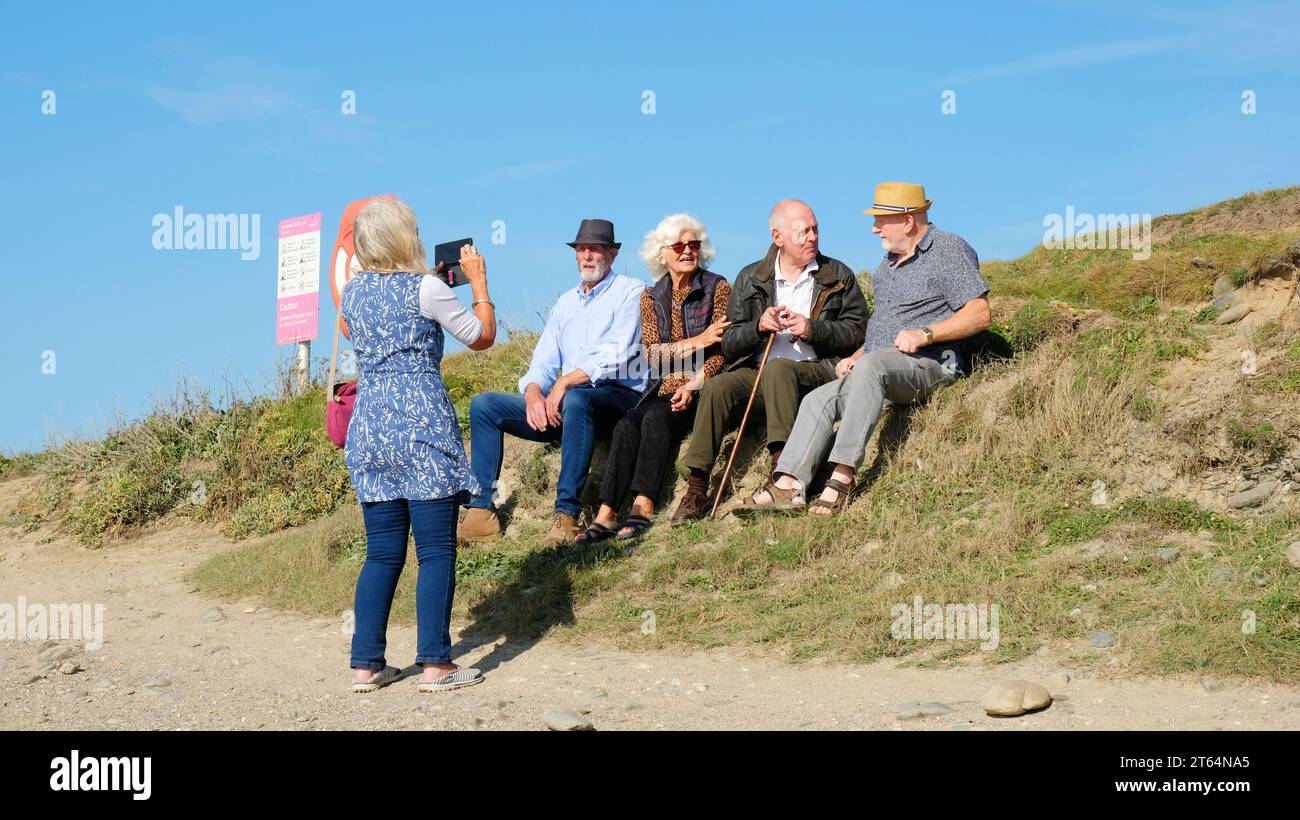 Group of seniors having their photograph taken in summer sunshine, Gunwalloe, Cornwall, UK - John Gollop Stock Photo