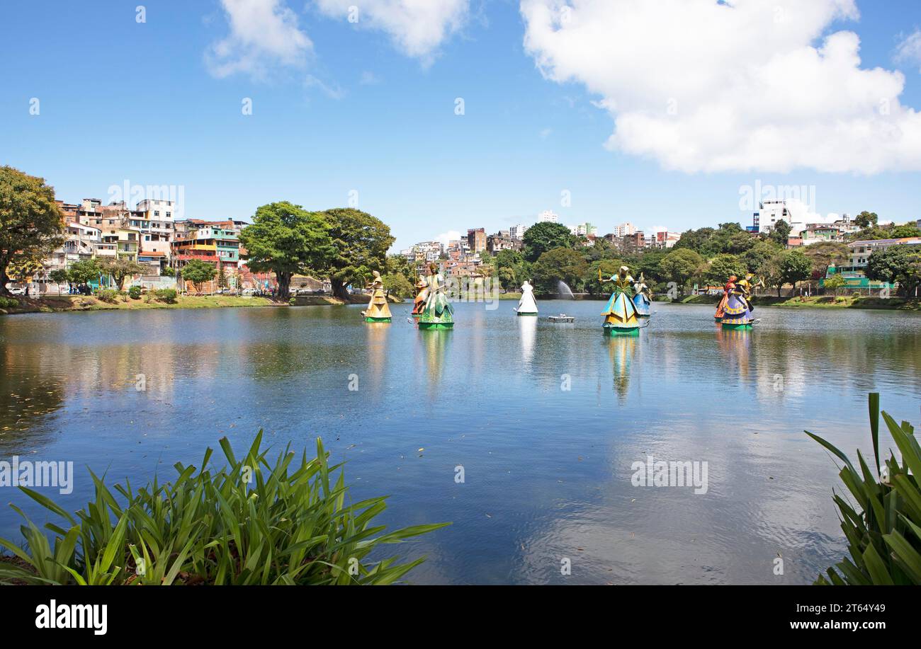 Sculptures of African deities on the natural spring lake Dique do Tororo, in the back typical dwellings, Salvador, State of Bahia, Brazil Stock Photo